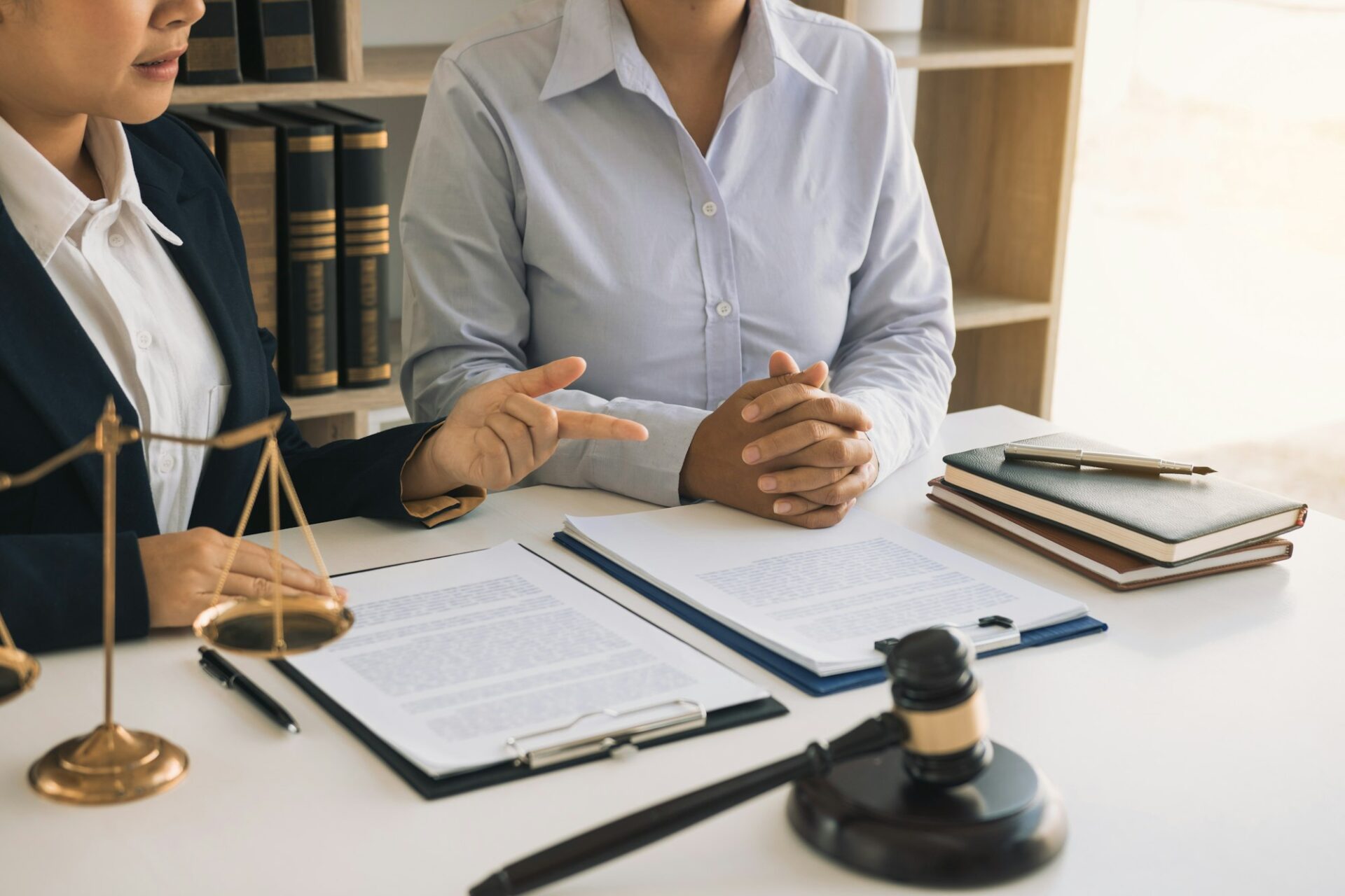 Legal advisor is explaining the offense under the law in the book at office.